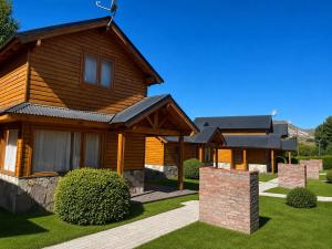 a wooden house with a pathway in front of it at Illihue - Cabañas, Hostería & Spa in Junín de los Andes