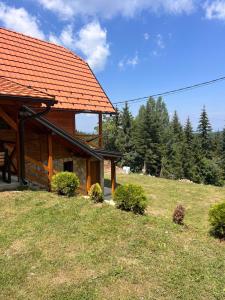 a log cabin with an orange roof on a hill at Brvnara Tarska Zora in Sekulić  +58 photos