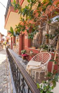 a balcony with a chair and a table on a building at Halil Bey Luxury Apartments in Kavála