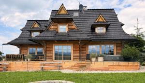 a log cabin with a gambrel roof at Tatra Whisper Chalet in Ząb