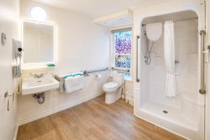 a bathroom with a toilet and a sink and a shower at Rum Runner Inn in Lunenburg +47 photos