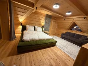 a bedroom with a bed and a couch in a room at Tatra Whisper Chalet in Ząb +27 photos