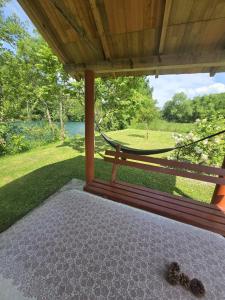 a porch with a hammock and a view of a park at Home-Vasva and Hazim in Ćukovi