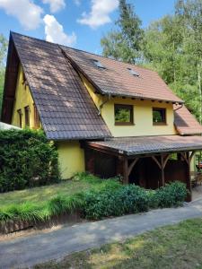 a yellow house with a brown roof at Mariolka Skorzęcin in Skorzęcin