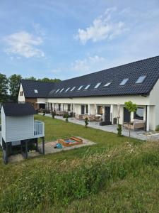 a house with solar panels on the roof at Sunrise Marina Domki Mielno- Ferienhaus in Mielenko
