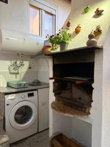 a kitchen with a washing machine and a sink at El renacer de Flor - Casa turística in Chandreja