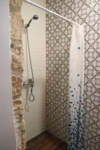 a shower in a bathroom with a shower curtain at The Essence Tzimer in Safed