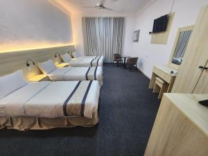 a hotel room with three beds and a desk at Rahat Alubur Hotel in Medina +14 photos