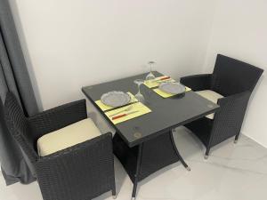 a black dining room table with chairs and a lamp at Apartments Aroma in Tomba