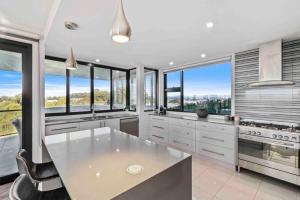 a kitchen with white cabinets and windows with a view at Seabreeze Sanctuary in Long Beach