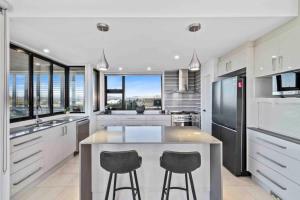 a kitchen with a large island with two bar stools at Seabreeze Sanctuary in Long Beach