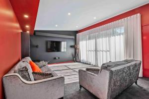 a living room with two couches and a red wall at Seabreeze Sanctuary in Long Beach