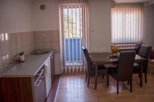 a kitchen with a table and chairs and a sink at Modex Apartments in Paraćin