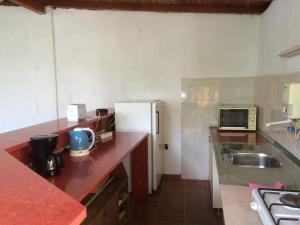 a small kitchen with a refrigerator and a sink at Guest House Kiwi in Golden Sands