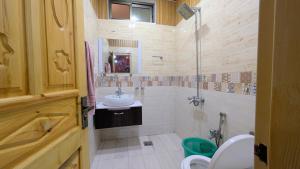 a bathroom with a sink and a shower and a toilet at Afridi Apartment in Murree