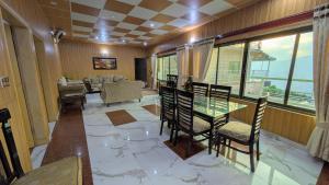 a living room with a glass table and chairs at Afridi Apartment in Murree