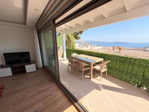 a patio with a table and chairs and a television at BODRUM BURCU RESIDENCE, Magnificent Sea View, Cozy, Free Otopark, Free Wifi in Bodrum City