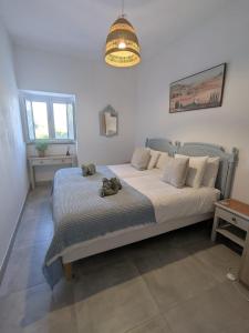 a bedroom with a bed in a room with a chandelier at Quinta Do Priorado in Moncarapacho