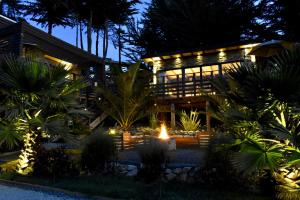 a house lit up at night with lights at ONDA DE MAR VILLAS - Solo para Dos - Vistas al Mar - Sesión Hidromasaje Incluida - Quincho - Privacidad in Pichilemu