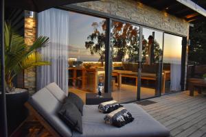 a living room with a couch on a wooden deck at ONDA DE MAR VILLAS - Solo para Dos - Vistas al Mar - Sesión Hidromasaje Incluida - Quincho - Privacidad in Pichilemu