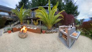a backyard with a fire pit and a house at ONDA DE MAR VILLAS - Solo para Dos - Vistas al Mar - Sesión Hidromasaje Incluida - Quincho - Privacidad in Pichilemu +29 photos