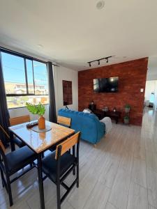 a living room with a blue couch and a table at Dpto familiar moderno 2do piso - 2 Hab - 3 camas - wifi - lavadora in Tacna