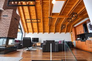 an open living room with wooden ceilings and furniture at Black Villa in Prizren