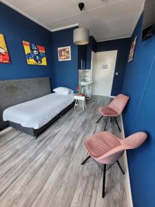 a bedroom with a bed and two chairs in it at Pension Delfzijl in Delfzijl