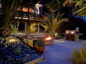 a courtyard with plants and a fire pit at night at ONDA DE MAR VILLAS - Solo para Dos - Vistas al Mar - Sesión Hidromasaje Incluida - Quincho - Privacidad in Pichilemu