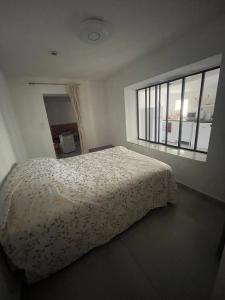 a bedroom with a bed and a large window at T2 avec terrasse privative Berre-l'Étang in Berre-lʼÉtang
