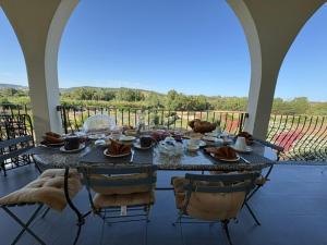 a table and chairs on a porch with a view at Les Lauriers, chambre d'hôtes in Siamanna