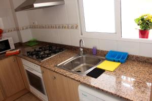 a kitchen counter with a sink and a stove at Apartamentos Guillem in Playa de Miramar