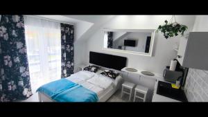 a small bedroom with a bed and a mirror at VILLA KINGA ROWy in Rowy