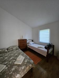 a bedroom with a bed and a dresser and a window at Gabi in Ðuraševići
