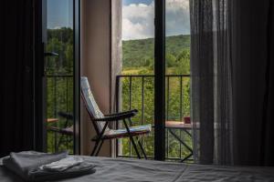 a room with a bed and a balcony with a chair at Kechi home 6 in Tsaghkadzor