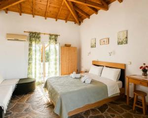 a bedroom with a large bed and a desk at Oasis Studios Skala Kallonis in Skala Kallonis