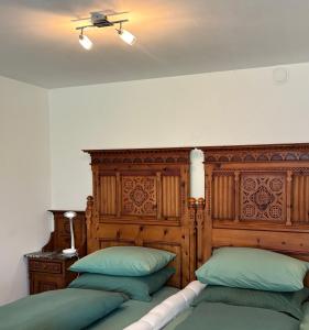 a bedroom with two beds and a wooden headboard at Vorderschöneck 2 in Longostagno