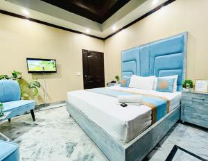 a bedroom with a large bed with a blue headboard at Hotel Johar View in Lahore