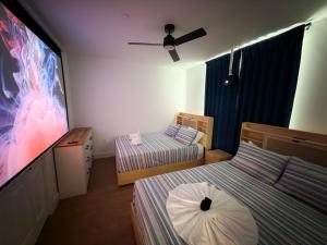 a room with two beds and a flat screen tv at 1 Block to Beach 150" Theater PS5 Arcade in Seaside Heights