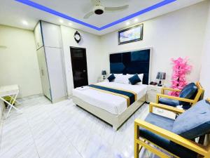 a bedroom with a king sized bed and a chair at Hotel Johar View in Lahore
