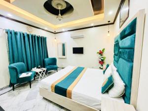 a hotel room with a bed and two chairs at Hotel Johar View in Lahore