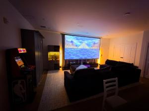 a living room with a large flat screen tv at 1 Block to Beach 150" Theater PS5 Arcade in Seaside Heights