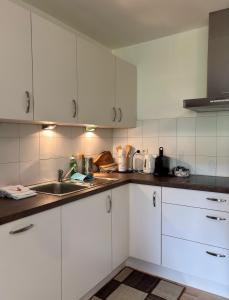 a kitchen with white cabinets and a sink at Vorderschöneck 2 in Longostagno