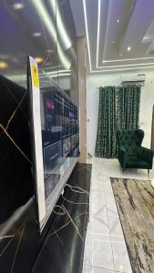 a room with a television and a green chair at Emilomo beautiful homes in Cardoso +2 photos