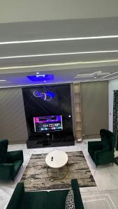 a living room with green furniture and a large screen tv at Emilomo beautiful homes in Cardoso
