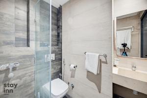 a bathroom with a toilet and a glass shower at Hotel STAY INN in Agadir +27 photos