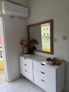 a white dresser with a mirror on top of it at Papaya Condo in Portsmouth