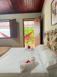 a bedroom with a white bed with towels on it at Pousada Almar in Itacaré