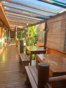 a wooden deck with benches and tables on it at Pousada Almar in Itacaré