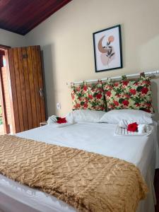 a bedroom with a large bed with red flowers on it at Pousada Almar in Itacaré
